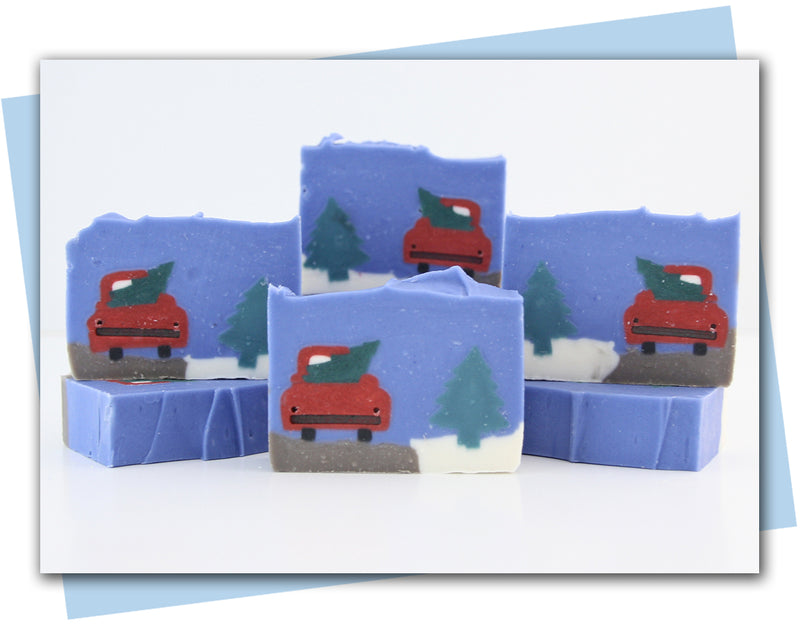 Soap bars with red truck and Christmas tree design on a white card with blue border