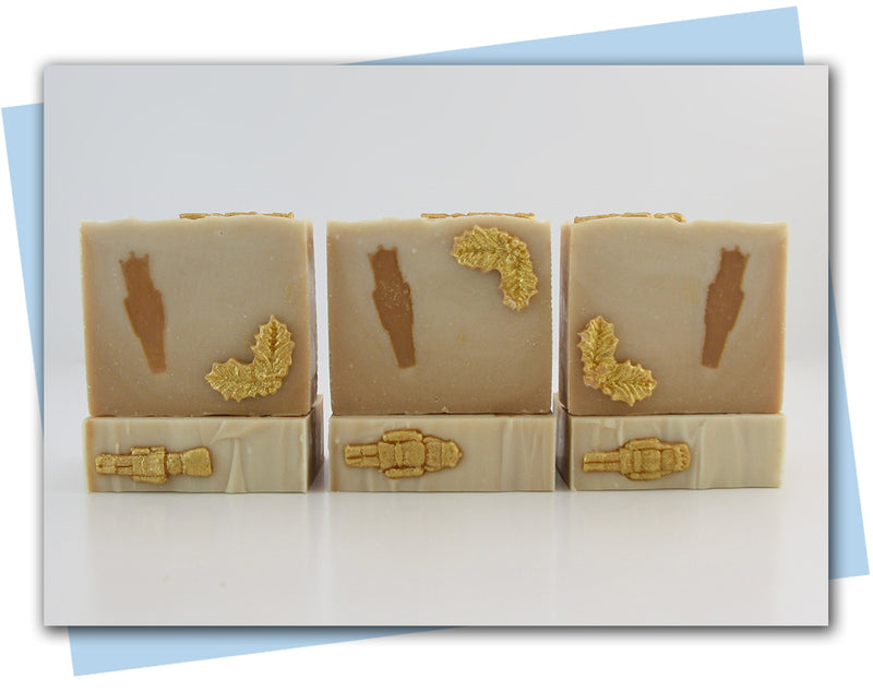 Gold to light gold ombre bars of soap with nutcracker embed and holly leaf embellishments