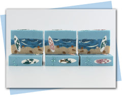 Beach scene with shells and surfboard sittnig in the sand with ocean background bars of soap