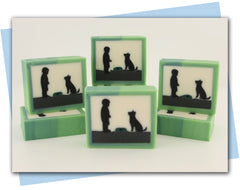 A boy and his dog at feeding time.  Bar soap with a silhouette design and a green ombre frame.