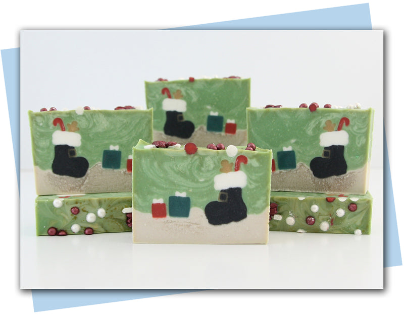 Santa's boot with a candy cane and gingerbread man inside and presents sitting in the snow bars of soap