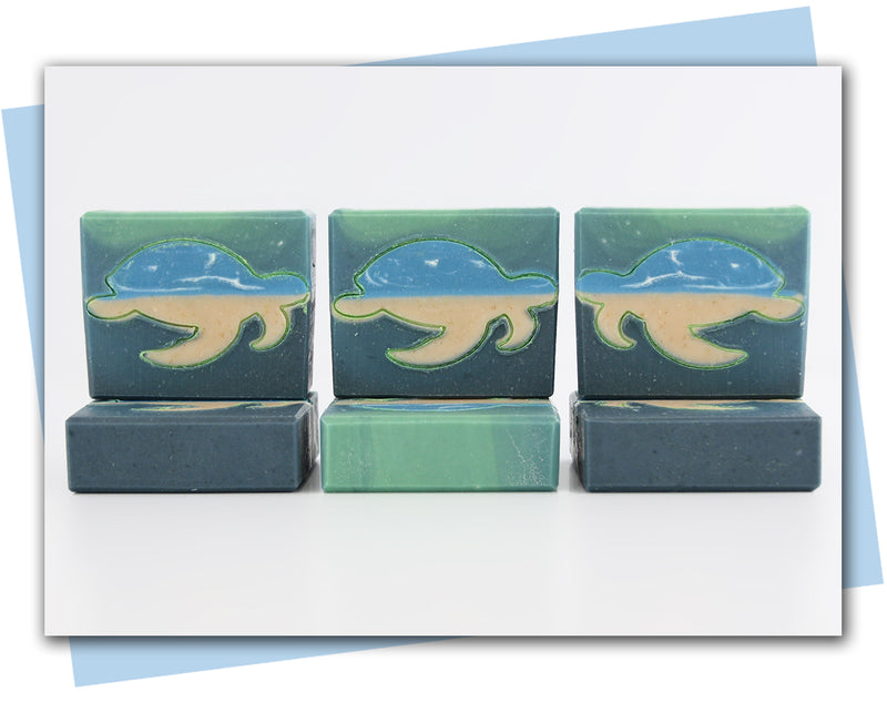 Green ombre bar of soap with turtle outline that is infilled with an ocean scene