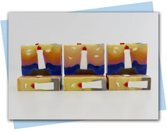 BArs of soap with a pink to yellow sunset sky ombre with a lighthouse and seagull embeds